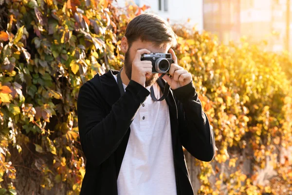 Trendiga hipster man tar foto utomhus — Stockfoto