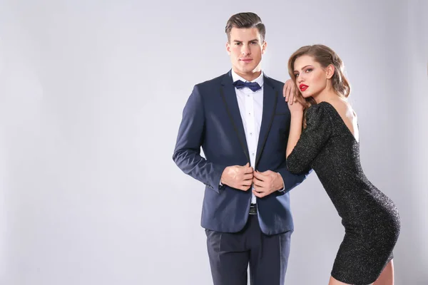 Sexy Frau und Geschäftsmann im Anzug auf grauem Hintergrund — Stockfoto