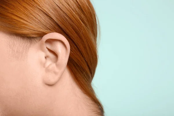 Mujer joven sobre fondo de color. Problema de audición — Foto de Stock