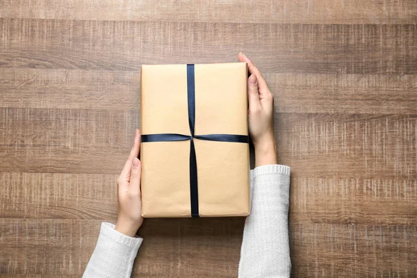 Woman with parcel box on wooden background — Stock Photo, Image