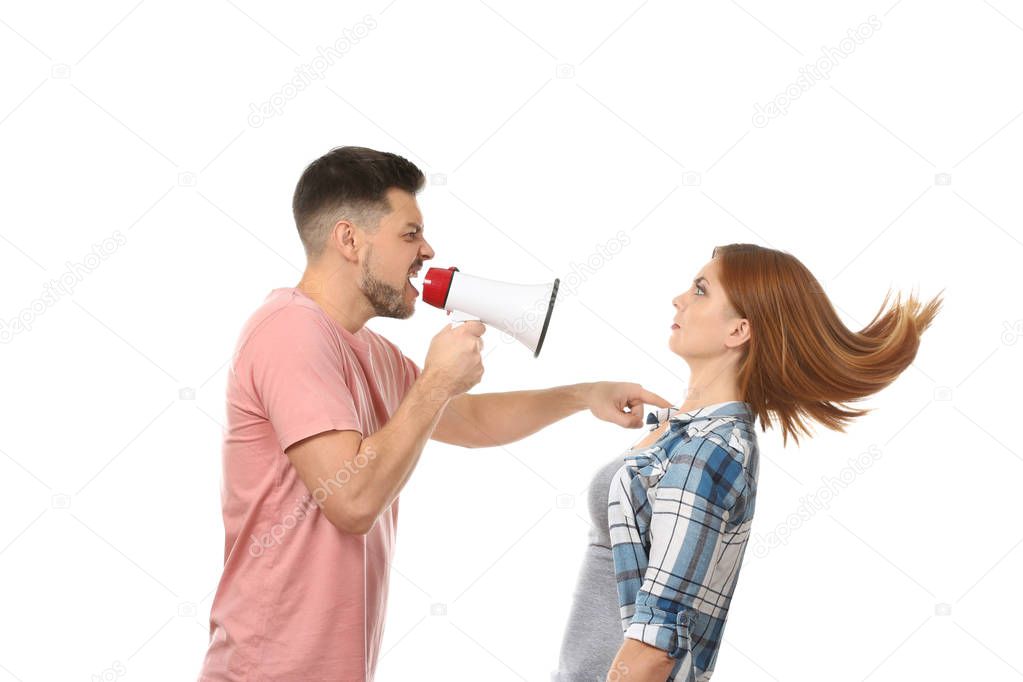Angry man with megaphone scolding his wife on white background