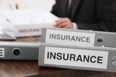 Klasörler belgeleri ve arka planda çalışan adam. Sigorta kavramı