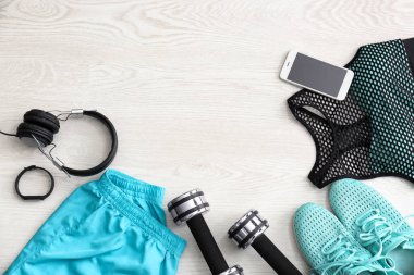 Spor malzeme, cep telefonu ve ahşap arka plan üzerinde egzersiz planı için boş alan. Düz yatıyordu kompozisyon