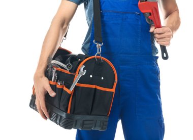 Alet çantası ve beyaz arka plan üzerinde beyinameliyatı üniformalı genç tesisatçı