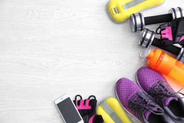 Spor malzeme, cep telefonu ve ahşap arka plan üzerinde egzersiz planı için boş alan. Düz yatıyordu kompozisyon