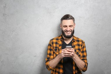 Cep telefonu gri arka plan üzerinde olan yakışıklı adam portresi