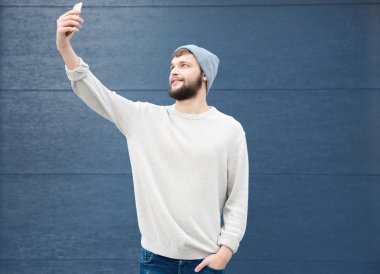 Selfie renk arka plan üzerinde çekici trendy hipster adam