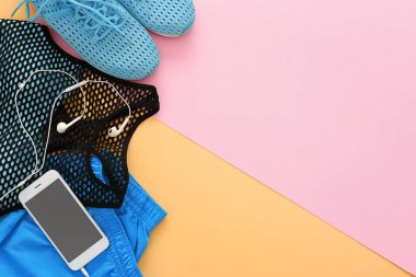 Spor malzeme, cep telefonu ve renk arka plan üzerinde egzersiz planı için boş alan. Düz yatıyordu kompozisyon