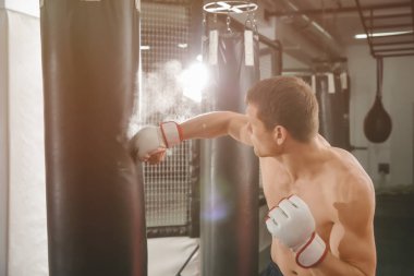 Erkek boxer kum torbası içinde jimnastik salonu ile eğitim