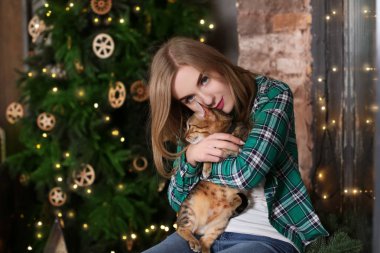Güzel genç kadın ile Noel ağacı evde yakınındaki sevimli kedi