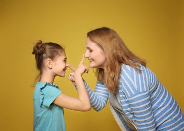 Mutlu anne ve kızı renk arka plan üzerinde eğleniyor