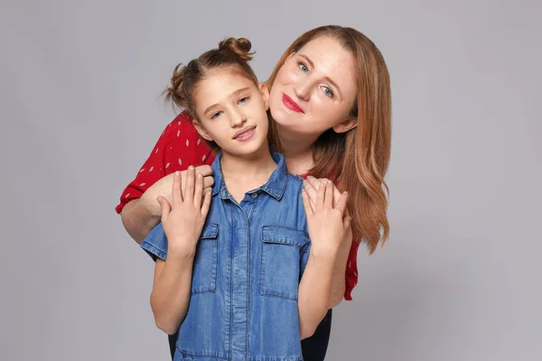 Porträt glücklicher Mutter und Tochter auf grauem Hintergrund — Stockfoto