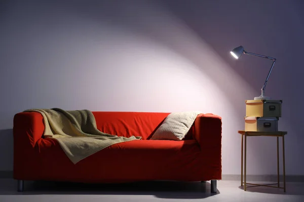Élégant salon intérieur avec canapé rouge confortable près du mur — Photo