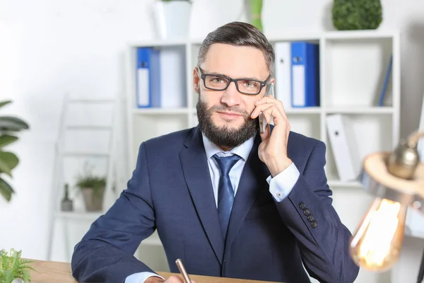 Stilig affärsman talar i mobiltelefon inomhus — Stockfoto