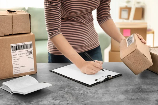 Junge Frau bereitet Pakete für den Versand an Kunden am Tisch im Homeoffice vor. Startup-Unternehmen — Stockfoto