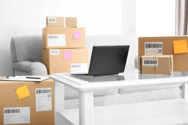 Ordenador portátil en la mesa y paquetes listos para su envío a los clientes en la oficina en el hogar. Empresas de nueva creación — Foto de Stock
