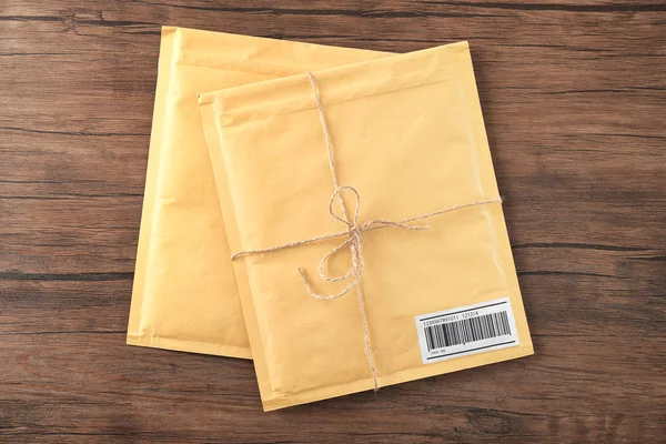 Envelopes acolchoados de presente na mesa de madeira — Fotografia de Stock