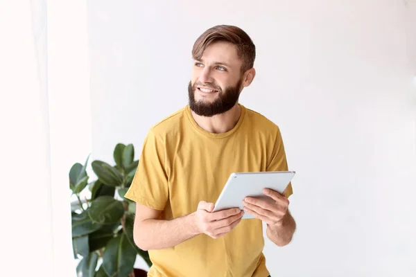Портрет красивого мужчины с планшетным компьютером в помещении — стоковое фото