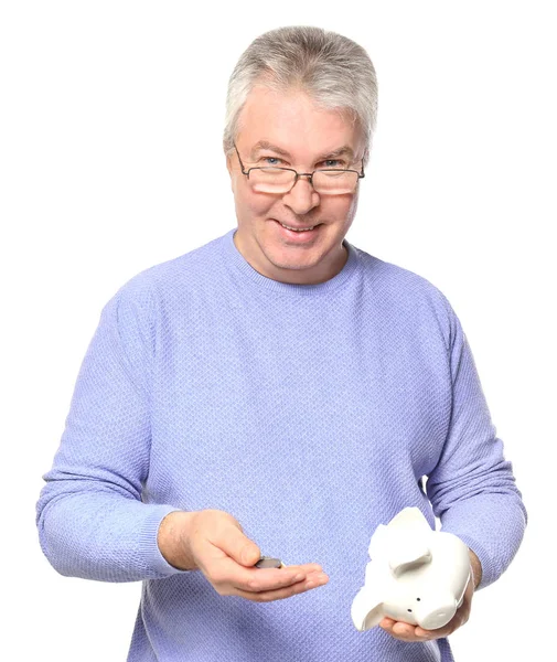 Hombre maduro sosteniendo alcancía rota con monedas sobre fondo blanco —  Fotos de Stock