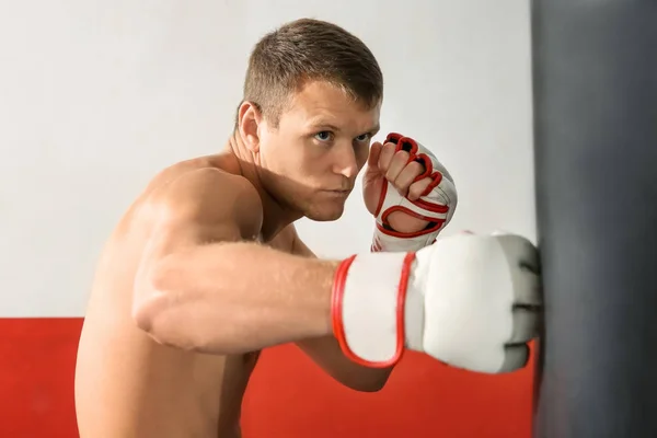 Entrenamiento de boxeador masculino con saco de boxeo en gimnasio —  Fotos de Stock