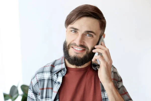 Bonito homem falando no celular dentro de casa — Fotografia de Stock