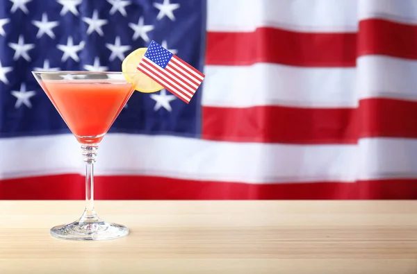 Glass of cocktail on table against flag of the USA — Stock Photo, Image