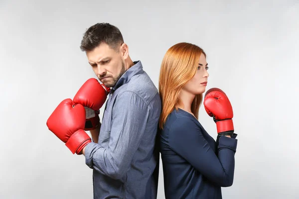 Casal irritado em luvas de boxe no fundo claro — Fotografia de Stock