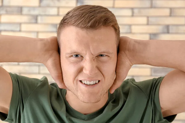 Az ember, amely a fülét a téglafal háttér. Probléma tárgyaláson — Stock Fotó