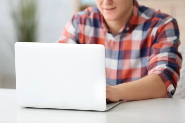 Man met laptop aan tafel binnenshuis — Stockfoto