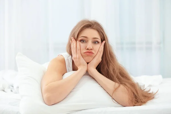 Portrét krásné emotivní ženy na posteli doma — Stock fotografie