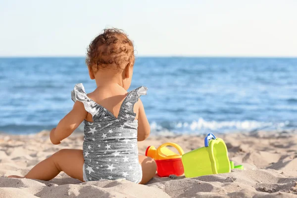 Niña jugando con juguetes de arena en la playa — Foto de Stock