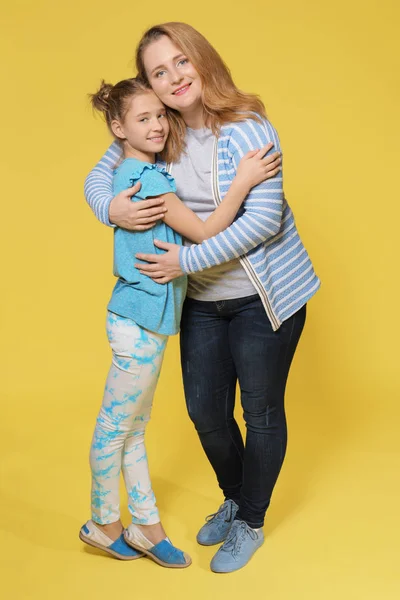 Portrait complet de mère et fille heureuses sur fond de couleur — Photo