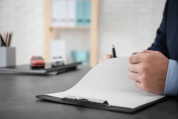 Hombre llenando el formulario de seguro de coche en la mesa —  Fotos de Stock