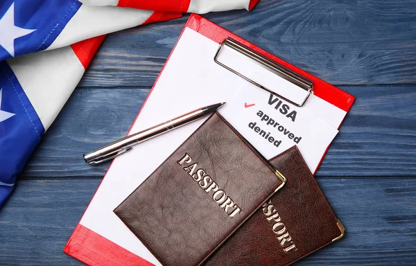 Passeports avec presse-papiers et drapeau américain sur fond en bois. Visa américain approuvé — Photo