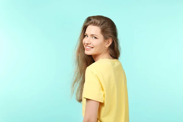 Portret van een mooie glimlachende vrouw op kleur achtergrond — Stockfoto