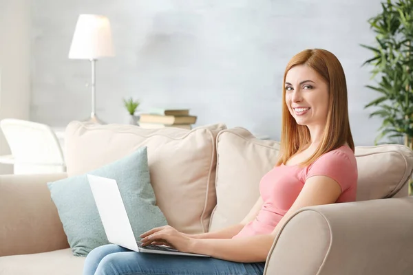 Hermosa mujer sonriente usando el ordenador portátil en casa —  Fotos de Stock