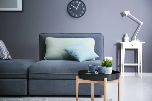 Belo interior de quarto moderno com sofá confortável e mesa elegante — Fotografia de Stock