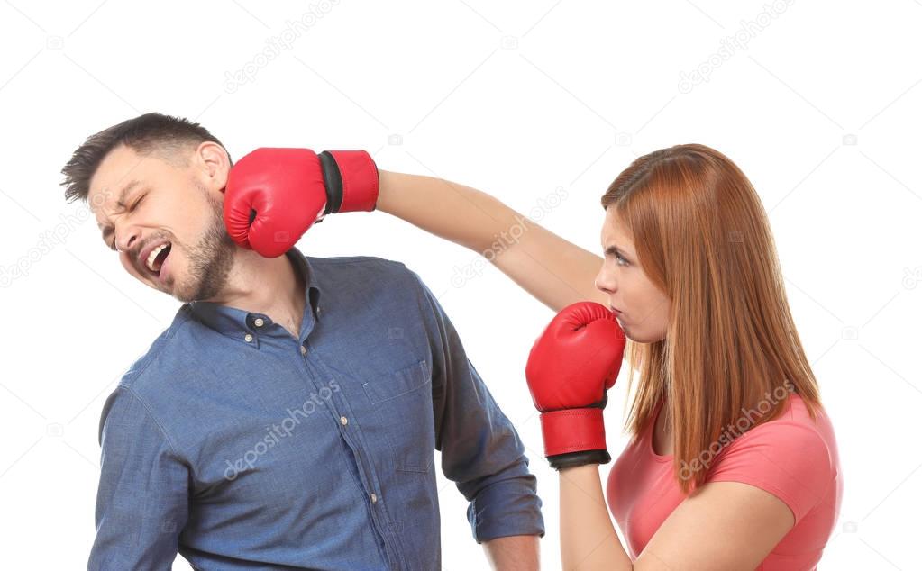 Angry couple in boxing gloves fighting on white background