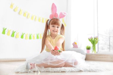 Sevimli küçük kız parlak Paskalya yortusu yumurta holding tavşan kulakları ile