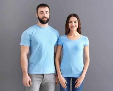 Genç erkek ve kadın şık t-shirt gri arka plan üzerinde. Mockup tasarım için