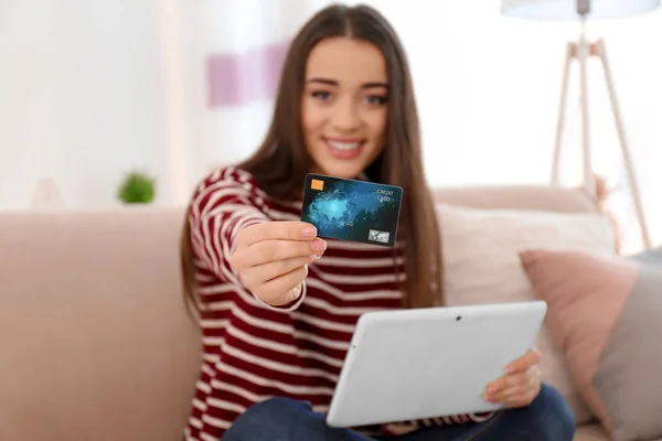 Young woman shopping online with credit card and tablet at home — Stock Photo, Image