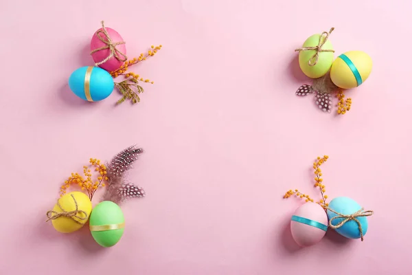 Huevos de Pascua decorados y mimosa sobre fondo de color — Foto de Stock