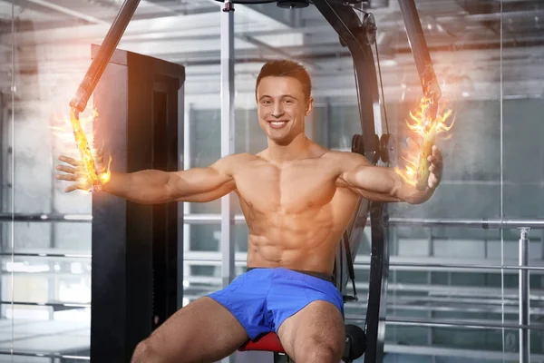 Musculoso joven culturista entrenamiento duro en el gimnasio — Foto de Stock