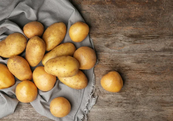 Batatas cruas frescas na mesa de madeira, vista superior — Fotografia de Stock