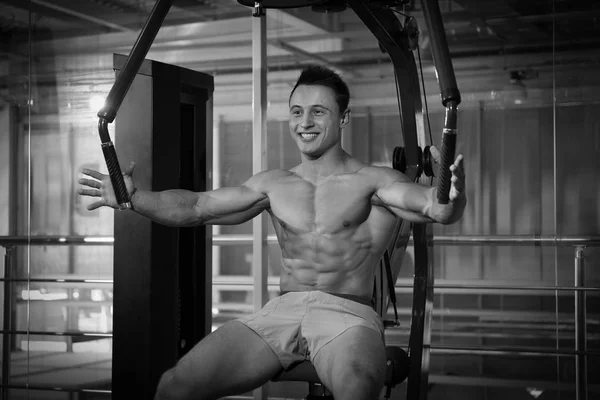 Muscular jovem fisiculturista formação em ginásio, efeito preto e branco — Fotografia de Stock