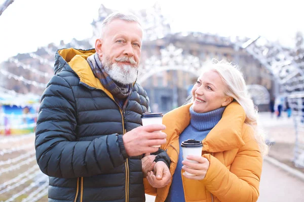 Счастливая зрелая пара с кофе на открытом воздухе — стоковое фото