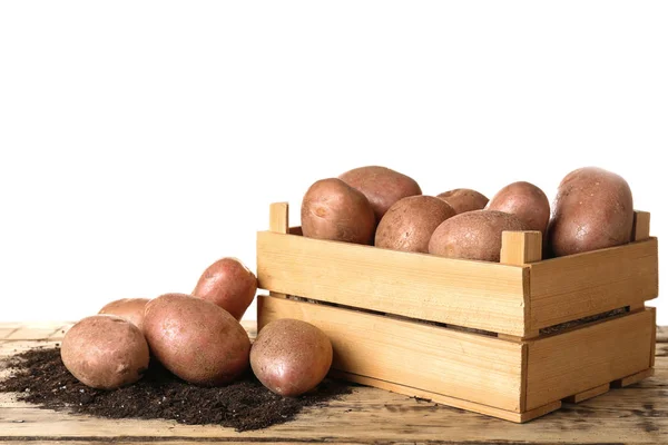 Wooden container with fresh raw potatoes on table against white background — Stock Photo, Image