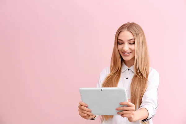 若いです女性とタブレットコンピュータ上の色の背景 — ストック写真