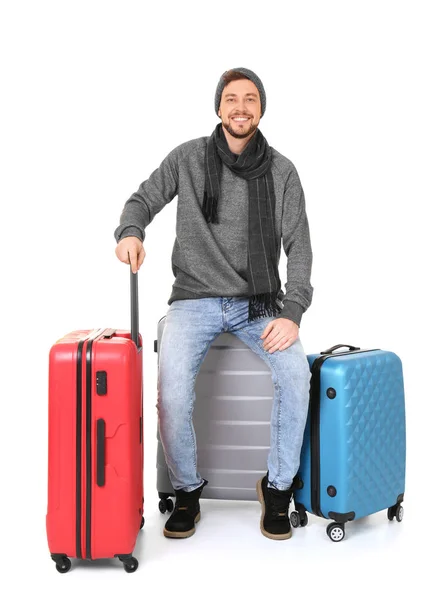Νεαρός άνδρας για ζεστό ρουχισμό με τις αποσκευές σε άσπρο φόντο. Είστε έτοιμοι για χειμερινές διακοπές — Φωτογραφία Αρχείου