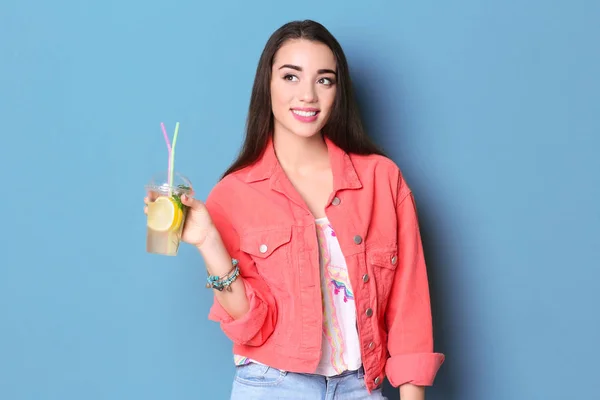 Lezzetli ferahlatıcı limonata renk arka plan üzerinde olan kadın — Stok fotoğraf